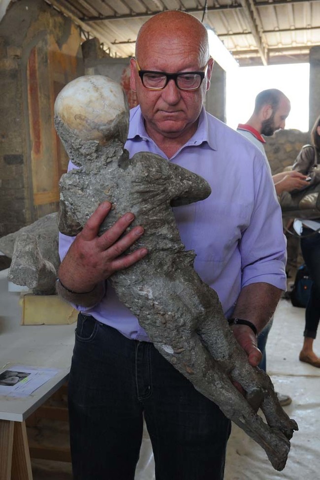 Stefano Vanacore, director of the laboratory of Pompeii Archaeological Site, carries a petrified victim of the eruption of Vesuvius volcano in 79 BC, during the restoration work and the study of 86 casts, on May 20, 2015 in Pompeii Archaeological site.   AFP PHOTO / MARIO LAPORTA        (Photo credit should read MARIO LAPORTA/AFP/Getty Images)