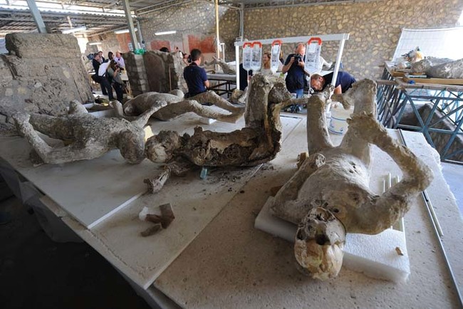 Restorers work on petrified victims of the eruption of Vesuvius volcano in 79 BC, as part of the restoration work and the study of 86 casts in the laboratory of Pompeii Archaeological Site, on May 20, 2015 in Pompeii.   AFP PHOTO / MARIO LAPORTA        (Photo credit should read MARIO LAPORTA/AFP/Getty Images)